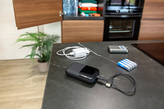 Emergency kit with analog portable radio, power bank, batteries and phone charger ready to listen news or advices during electrical blackout. 72 hour survival kit stored in pantry closet on background
