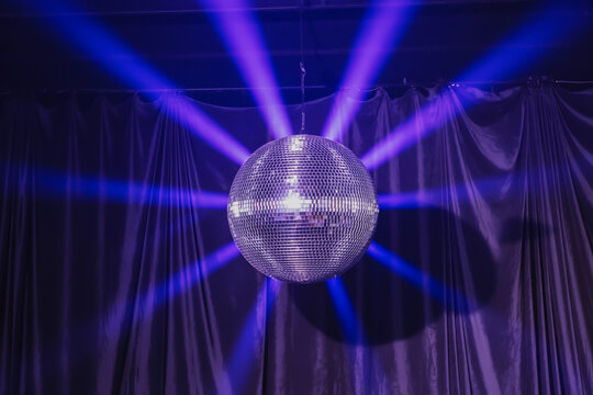 Sparkling disco ball with purple light beams mirror ball