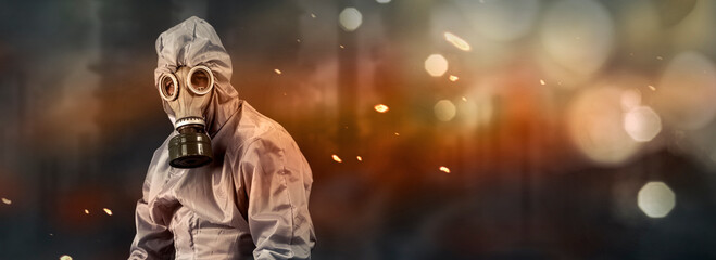 A man in a gas mask and protective suit. Environmental pollution concept. Dirty air with dust and...