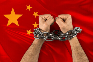 Men's hands chained against the flag of China