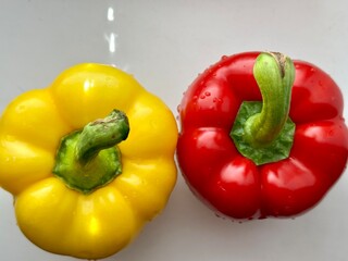 Extreme close-up of glossy red and yellow bell peppers. A vibrant, healthy food shot ideal for clean eating, nutrition topics, or vegan content creation.


