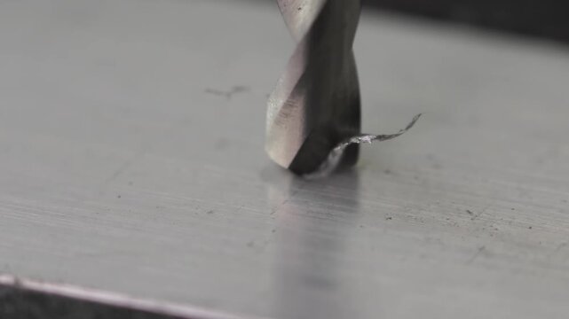 Metal drill bit makes hole in metal billet on industrial drilling machine. Metal work industry