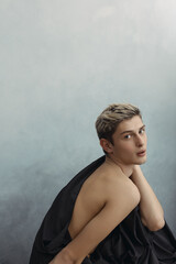 Artistic Portrait Of Young Man With Bare Shoulders Posing Elegantly 