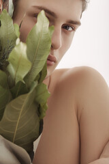 Close-Up Portrait Of Young Man Holding Greenery Bouquet In Soft Lighting 