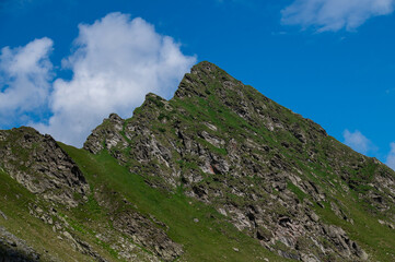 Fototapeta premium Steep rocky ridge under a clear sky in the Fagaras Mountains, Romania. Summer hiking scenery. 