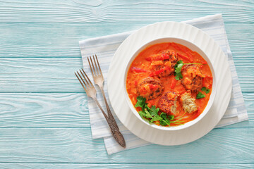 fish cakes in tomato vegetable coconut milk sauce