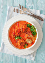 fish cakes in tomato vegetable coconut milk sauce