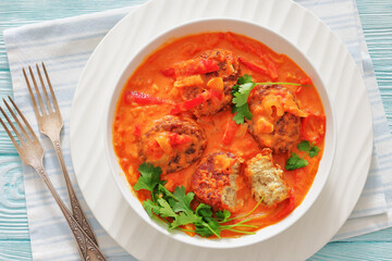 fish cakes in tomato vegetable coconut milk sauce
