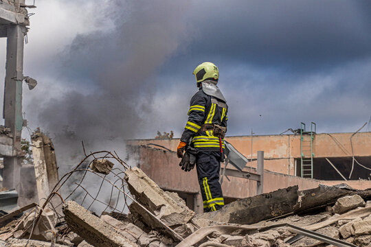 Firefighter standing on building ruins amid fire