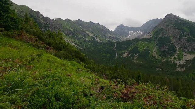 Vajanskeho vodopad, Temnosmrecinska and Hlinska dolina and peaks of High Tatras mountains from hiking trail to sedlo Zavory in Slovakia during cloudy early summer day