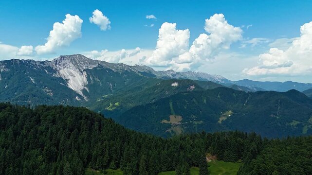 Aerial hyperlapse showcasing Karawanks Mountains, including Ko&scaron;uta and Veliki Vrh peaks, along Slovenian-Austrian borde
