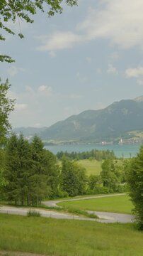Vertical: Lake Wolfgang in the Salzburg Alps region on a sunny summer day in Austria, medium shot, pan
