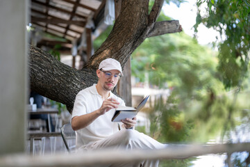 man is sitting under a tree reading a book