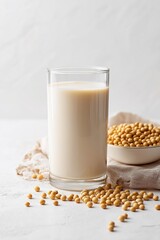 A refreshing glass of soy milk beside a bowl of soybeans, emphasizing healthy beverage choices and plant-based diets.