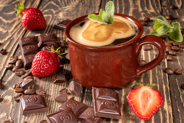 Delightful coffee scene with lush strawberries and chocolate on rustic wood