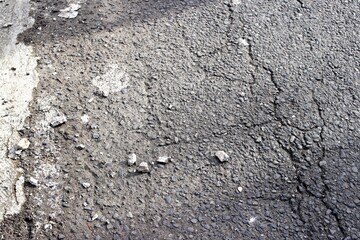 Naklejka premium The texture of asphalt with small stones on top. A background with detailed gray road surface. 