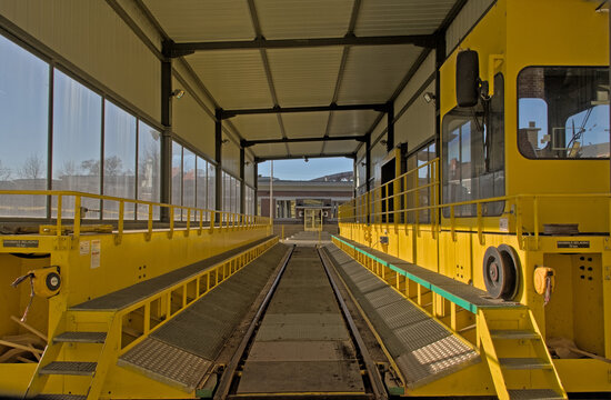 Sunny bright yellow mobile bridge for entrance to trains of an industrial stockroom 