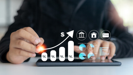 Hand using stylus on digital tablet with financial growth graph, percent bar chart, bank and credit...