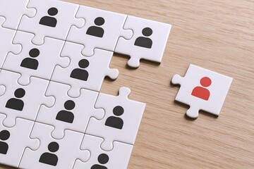Puzzle pieces with human icons representing teamwork cooperation collaboration or community.
