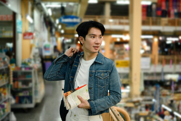 Stylish tourist glances around with a folded travel guide in hand, navigating a vibrant market
