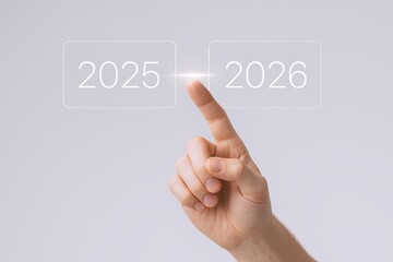 Human hand pressing transparent digital transition graphic from 2025 to 2026 with futuristic interface.