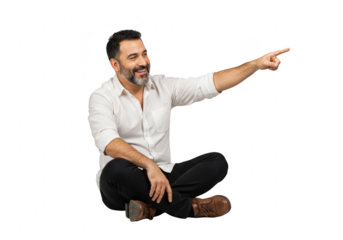 A smiling man with a beard sits crosslegged, pointing to the side with a happy expression, isolated on white isolated on transparent background