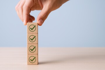Hand stacking wooden blocks with checkmarks symbolizing success or completion.