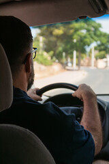 Man driving minivan on a sunny day