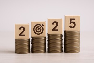 Wooden blocks with numbers and a target symbol on coins representing financial growth.