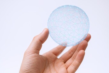 Hand holding futuristic glowing digital globe with network connections and technology theme.