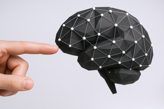 Human finger touching a geometric wireframe brain model representing artificial intelligence.