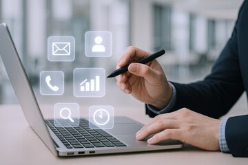 Business professional using digital interface with icons on laptop screen in office.