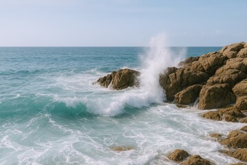 Fototapeta premium Serene coastal scene with crashing waves on rocky shoreline under blue sky.