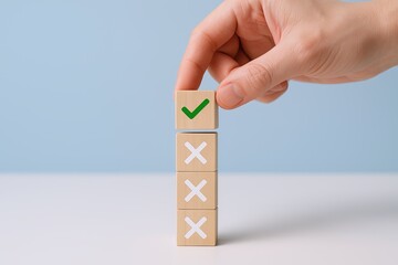 Hand holding wooden blocks stacked vertically with checkmark and cross symbols for decision making.