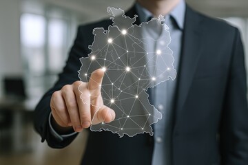 Businessman in formal suit pointing at digital map of Germany with network connection concept.
