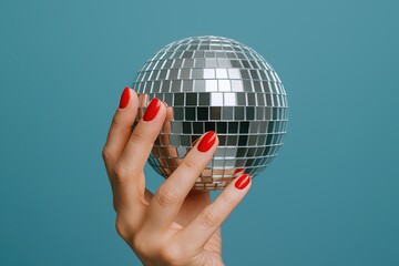 Elegant Hand Holding Small Disco Ball Against Solid Color Background for Party Theme.