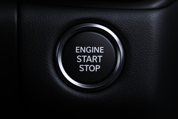 Close-up of engine start stop button in a modern vehicle interior with black textured dashboard.