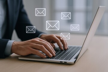 Business Professional Using Laptop Sending Multiple Email Messages in Modern Office.