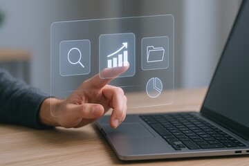 Futuristic transparent digital interface with data chart icons on laptop workspace.