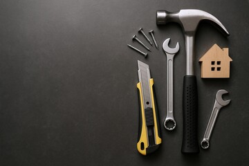 Set of Professional Hand Tools Including Hammer Wrench Screwdriver Nails and Small Wooden House Model on Dark Background.