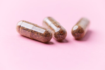 Siberian ginseng (Eleutherococcus senticosus) capsules on bright background. Soft focus. Close up. Copy space	