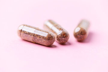 Siberian ginseng (Eleutherococcus senticosus) capsules on bright background. Soft focus. Close up. Copy space	
