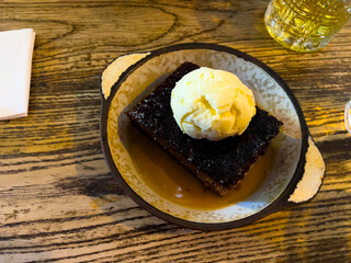 Traditional sticky toffee pudding with ice cream and a hint of whisky. A beloved British pub...