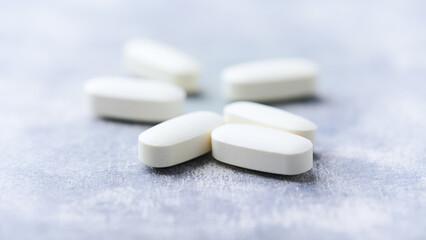 Amino acids tablets on wooden background. Soft focus. Close up	
