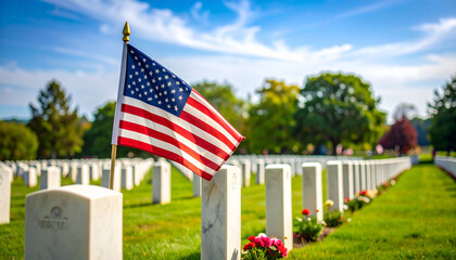 an american flag prominently displayed at a veterans cemetery, surrounded by graves marked with small american flags