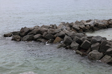 Obraz premium rocks brake waves in the water