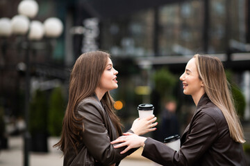 Women Laughing with Coffee Outdoors