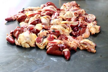 Chicken offal consisting of fresh heart, liver, and gizzard, sold at a traditional market. A delicious and nutritious cooking ingredient.