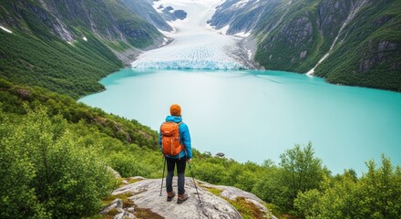 Hiker overlooking turquoise glacial lake and mountain landscape.