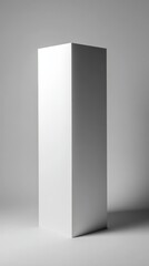 Naklejka premium A tall, white, rectangular prism stands on a smooth surface against a neutral gray background.